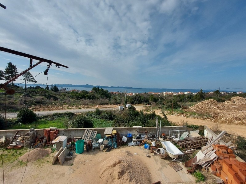 Widok na podwórko domu jednorodzinnego w budowie w Diklo koło Zadaru w Chorwacji, z rozrzuconymi materiałami