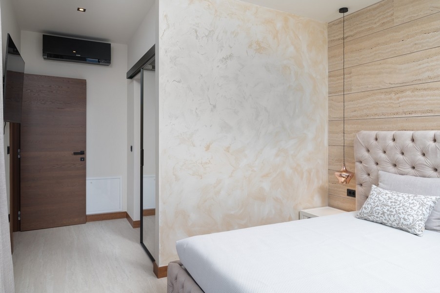 Nowocześnie zaprojektowana sypialnia z tapicerowanym zagłówkiem w willi na sprzedaż w Razanac, region Zadar, Chorwacja, z przesuwanymi drzwiami do korytarza