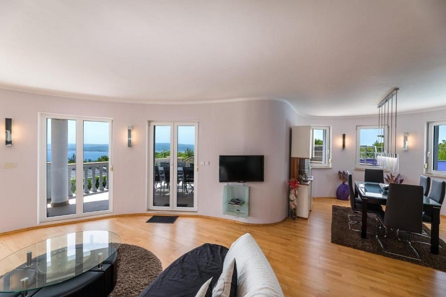 Pokój dzienny w apartamentowcu w Chorwacji z otwartym planem piętra i dostępem do tarasu z widokiem na morze