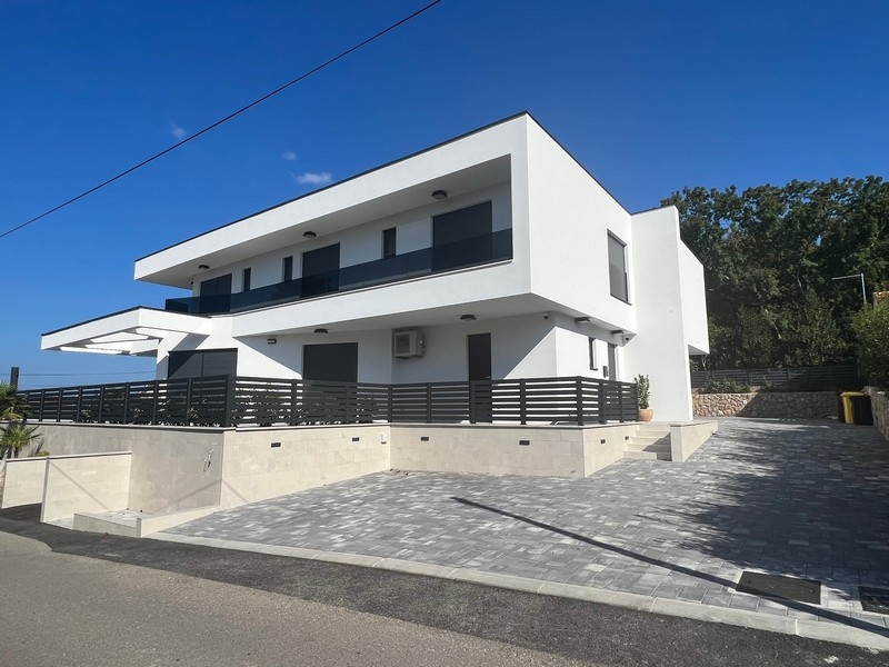 Widok na nieruchomość w Chorwacji: Biały bliźniak z dużymi oknami i betonowymi schodami zewnętrznymi w Njivicach.