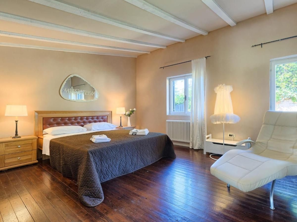 Duża sypialnia z drewnianymi podłogami i nowoczesnymi wygodami, aspekt luksusowych nieruchomości w Chorwacji