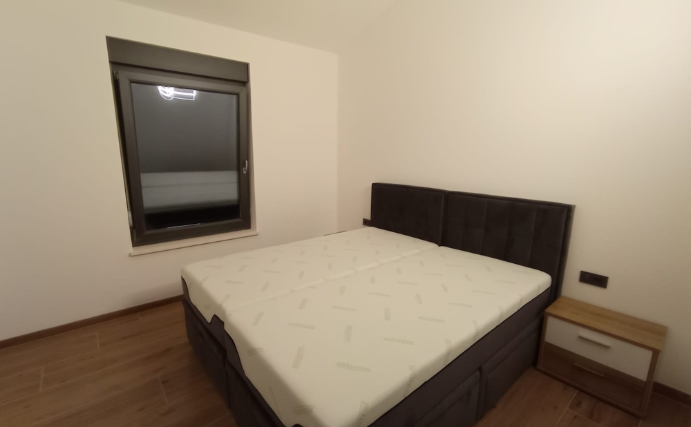 Prosta sypialnia z podwójnym łóżkiem w nieruchomości w Chorwacji, okno nocne zamknięte.