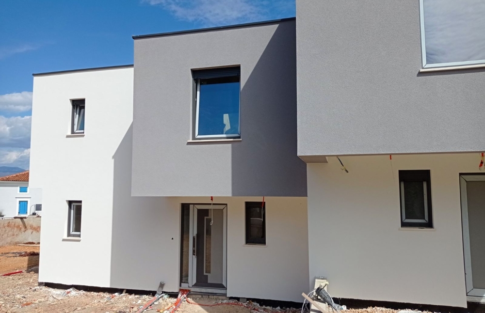 Widok z zewnątrz nowo ukończonej nieruchomości na sprzedaż w Chorwacji w ciągu dnia.