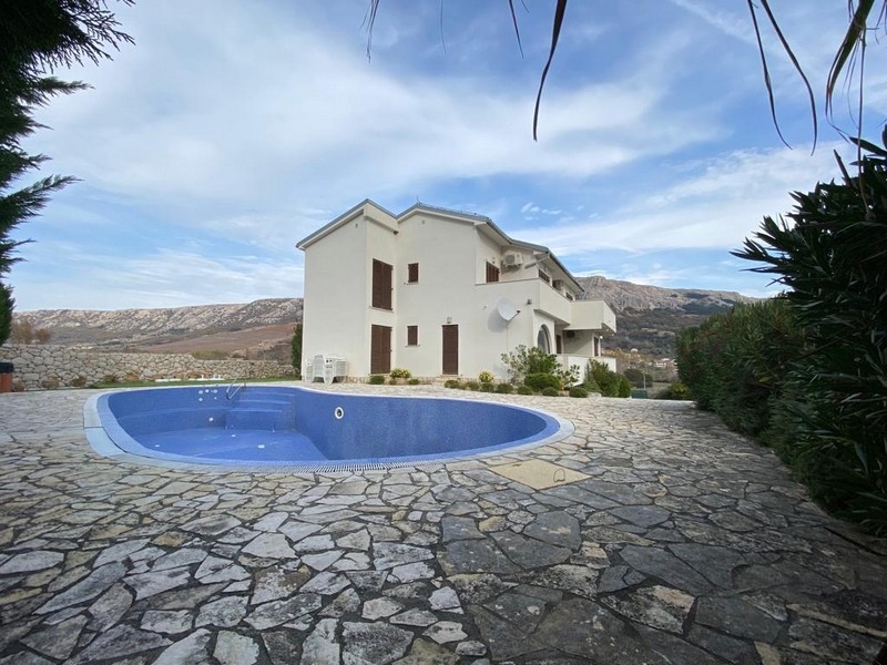 Widok zewnętrzny białego domu z okrągłym basenem i kamienną ścieżką, nieruchomość w Chorwacji