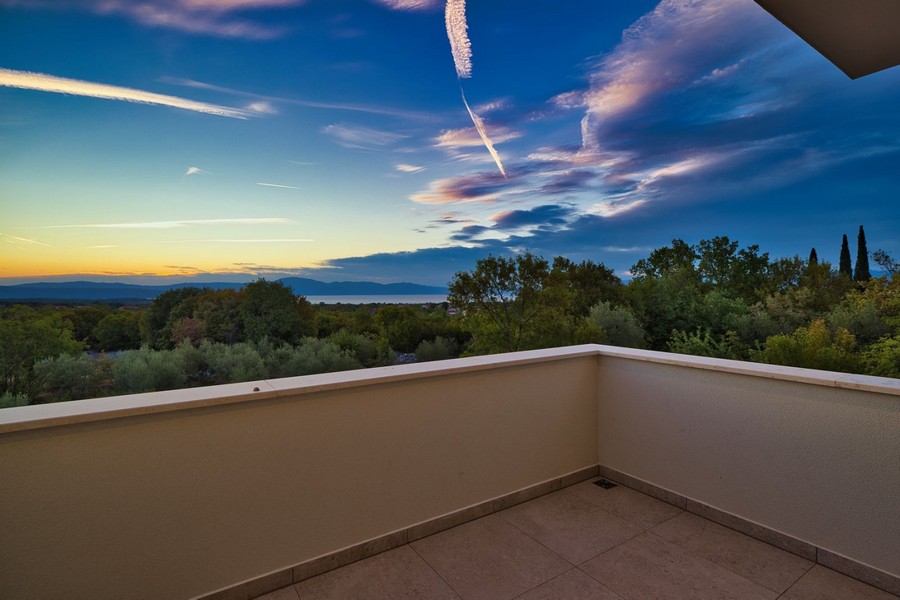 Widok z balkonu posiadłości na wyspie Krk z panoramicznym widokiem na malowniczy krajobraz o zmierzchu