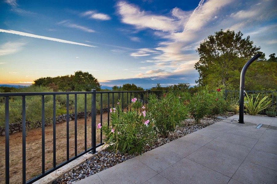 Zadbany ogród i naturalne otoczenie posiadłości na wyspie Krk z widokiem na morze w oddali