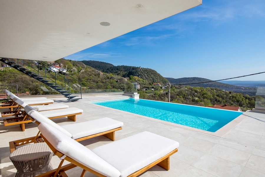 Taras przy basenie z leżakami i widokiem na morze, nieruchomość w Chorwacji, kup willę na wyspie Krk