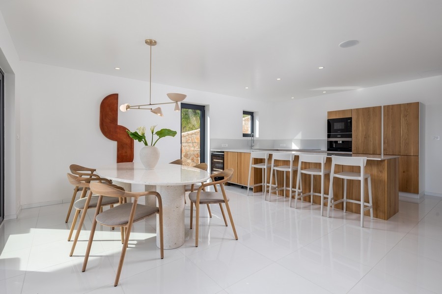 Jasna otwarta kuchnia ze stołem jadalnym i wyspą, nieruchomość w Chorwacji, willa na sprzedaż na wyspie Krk