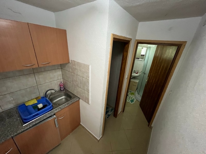 Mała kuchnia z przylegającym korytarzem w posiadłości na wyspie Krk, prezentuje styl minimalistyczny.