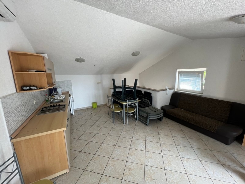 Przestronny salon przypominający poddasze z aneksem kuchennym, będący częścią nieruchomości na wyspie Krk.