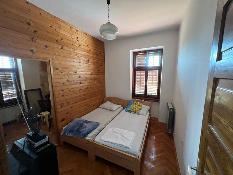 Przytulna sypialnia z drewnianymi ścianami i dwoma pojedynczymi łóżkami w nieruchomości na wyspie Krk.