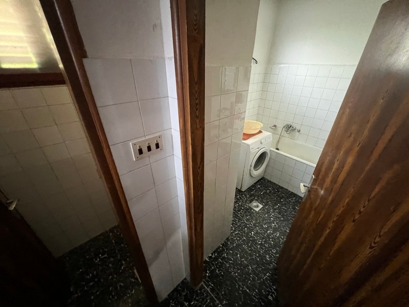 Prosta łazienka z pralką i toaletą przedstawia wyposażenie nieruchomości na wyspie Krk.