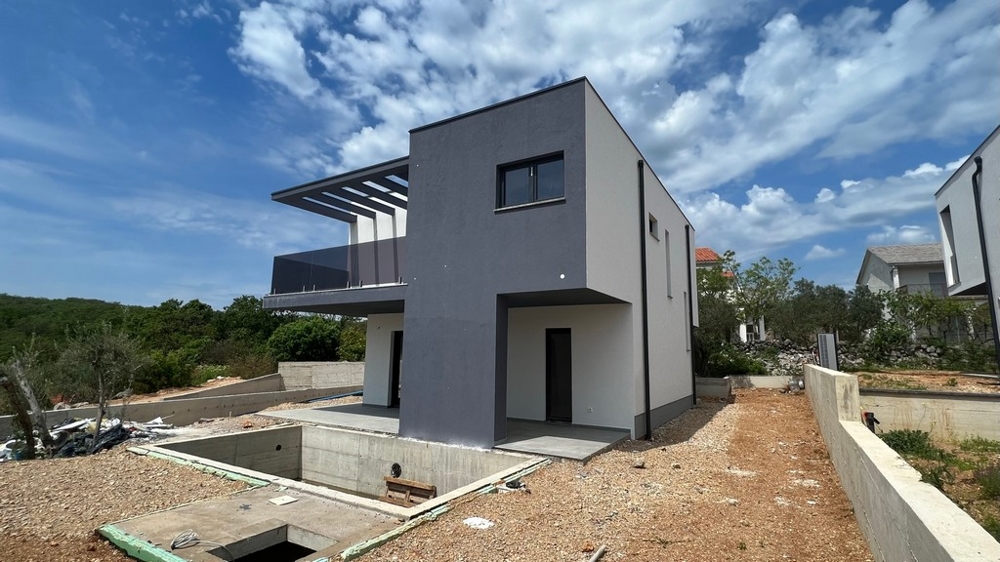 Nieruchomości Chorwacja, miasto Krk, wyspa Krk Willa na sprzedaż - widok z boku nowoczesnej willi z betonowym fundamentem i otaczającym krajobrazem