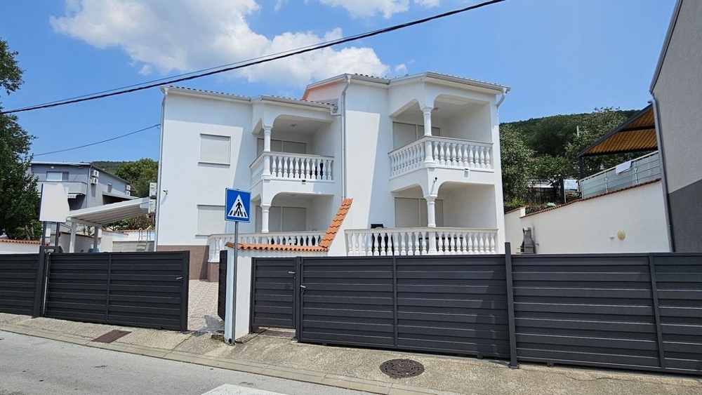 Widok zewnętrzny odnowionego domu bliźniaczego z żółtą fasadą i balkonami w Dramalj, region Crikvenica