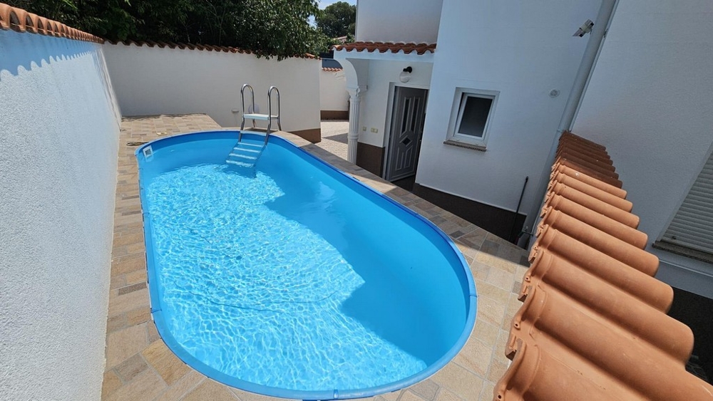 Wygląd zewnętrzny żółtego domu bliźniaczego z balkonami i schodami w zielonym ogrodzie