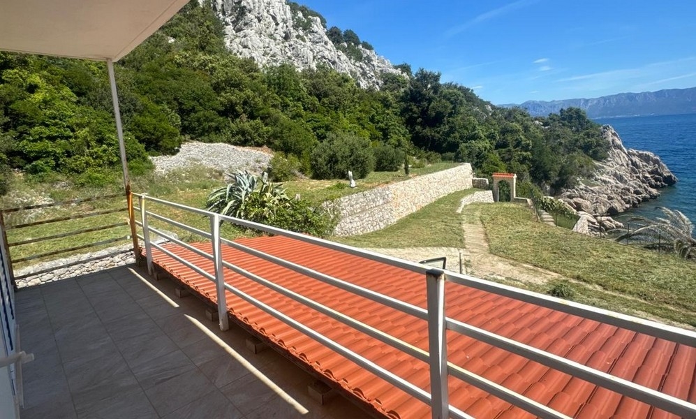 Willa z białą fasadą otoczona śródziemnomorską roślinnością i kamiennym łukiem, półwysep Pelješac