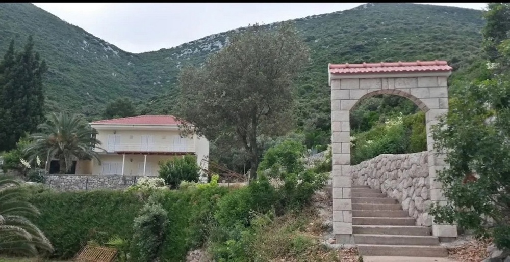 Widok z willi na morze i odległe góry przez otwarte szklane drzwi, półwysep Pelješac