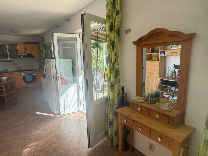 Widok przez szklane drzwi na taras nadmorskiej willi z aneksem kuchennym, półwysep Pelješac