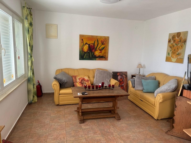 Przestronny salon z żółtymi sofami i dekoracyjnymi obrazami w nadmorskiej willi na półwyspie Pelješac