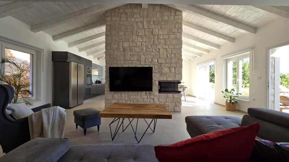 Nowoczesny salon z kanapą i telewizorem w stylu śródziemnomorskim.