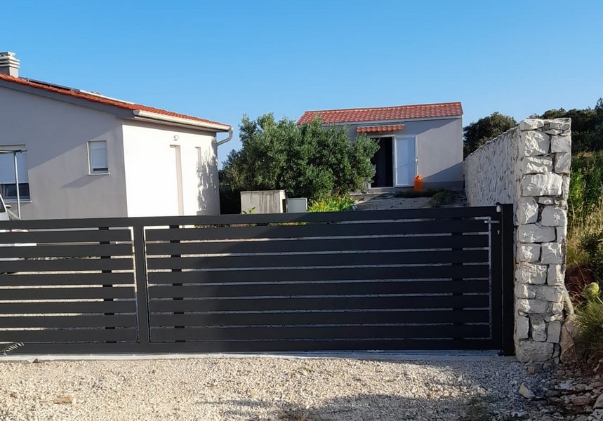 Jadalnia ze stołem i krzesłami obok kuchni, z widokiem na morze przez szklane drzwi.