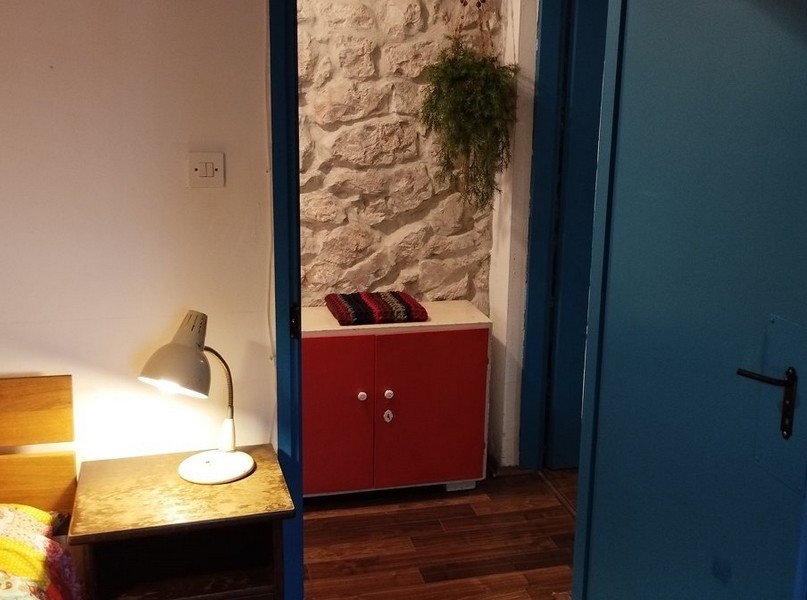 Sypialnia z kamiennymi ścianami i rustykalnym urokiem, idealna na zakup domu w Chorwacji.