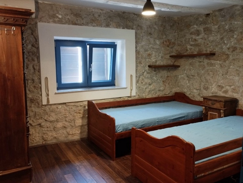 Sypialnia z dwoma pojedynczymi łóżkami, idealna dla rodzin chcących kupić dom w Chorwacji.