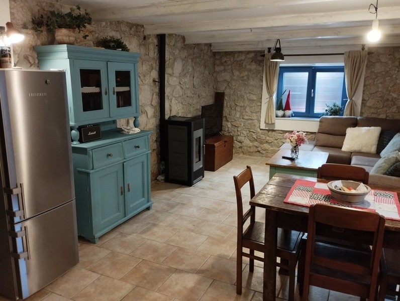 Otwarta część dzienna z jadalnią i tradycyjnym umeblowaniem, idealna na zakup domu w Chorwacji.