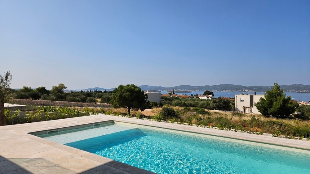 Widok na basen i morze w nieruchomości H3035 w Chorwacji.