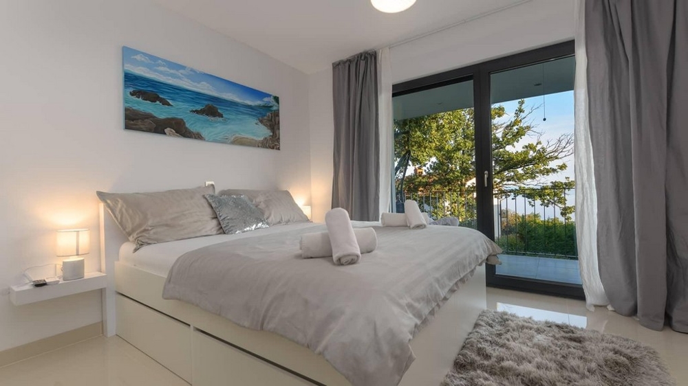 Przytulna sypialnia z balkonem i widokiem na bujną zieleń