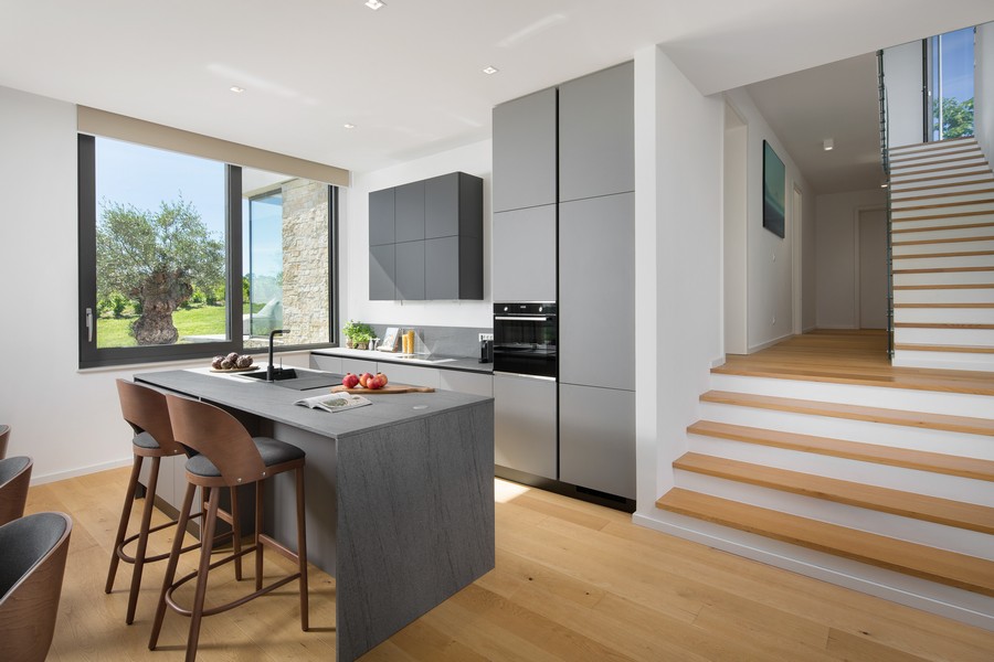 Kuchnia i jadalnia z barem oraz antresola i schody na piętro.