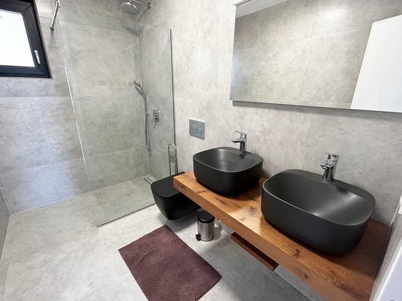 Nowoczesna łazienka w willi z podwójną umywalką i kabiną prysznicową