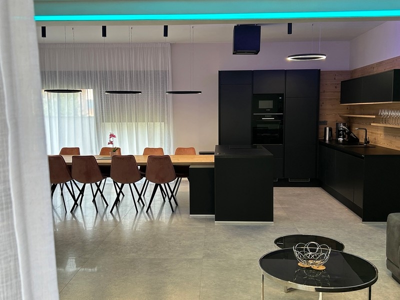 Otwarta kuchnia i jadalnia z widokiem na stół bilardowy i salon