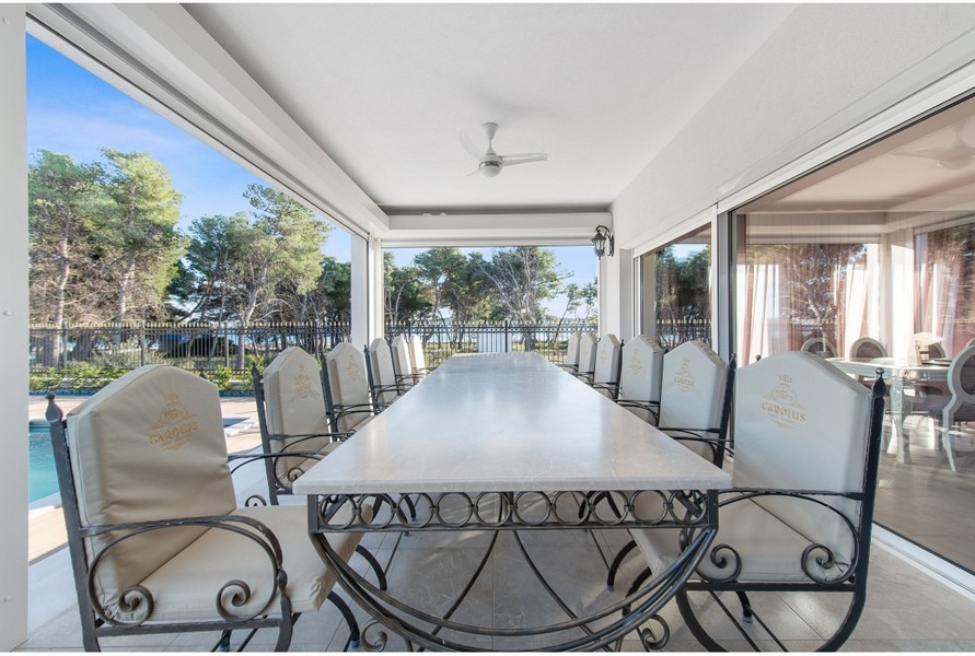 Zadaszona jadalnia Villa H3042 z dużym stołem i stylowymi krzesłami