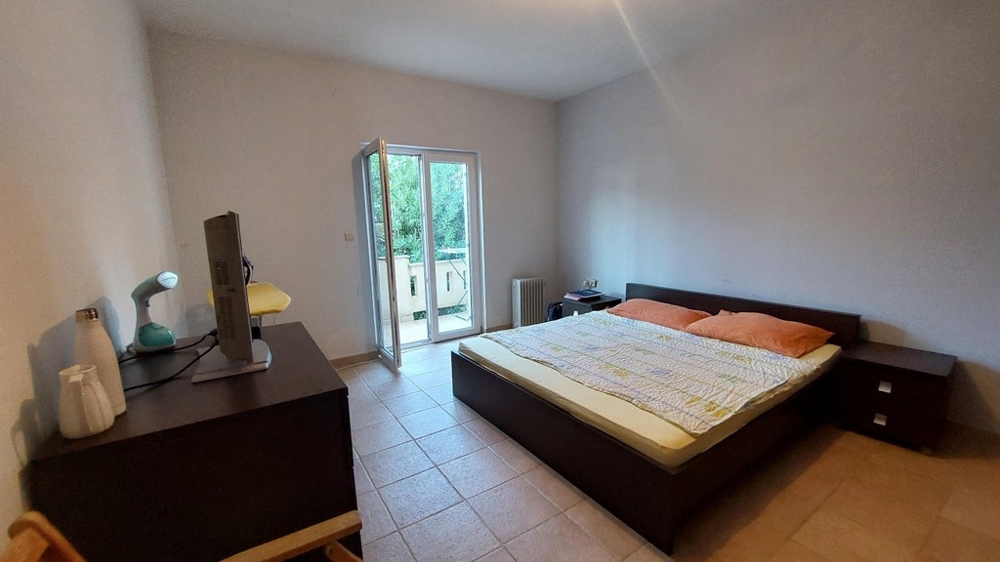 Sypialnia z podwójnym łóżkiem i dostępem do balkonu w domu w Chorwacji