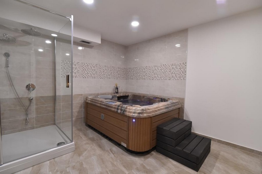 Łazienka z prysznicem i jacuzzi, oferowana przez agencję nieruchomości Panorama Scouting