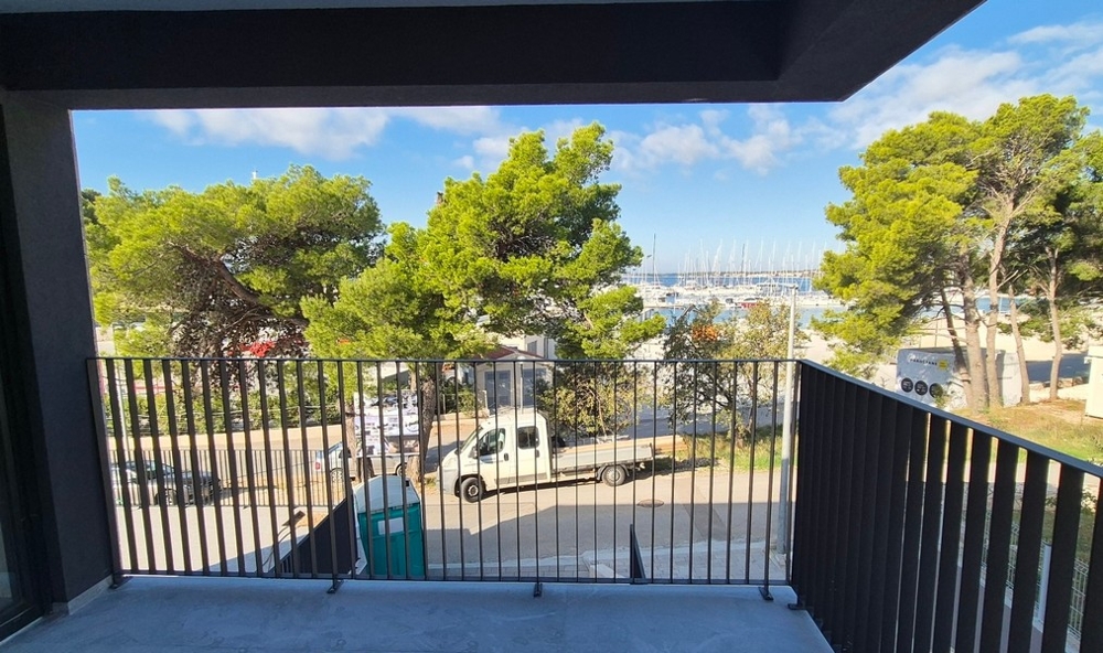 Taras współczesnej willi z basenem, leżakami i częścią wypoczynkową na świeżym powietrzu, otoczoną bujną zielenią w Drage w Chorwacji.