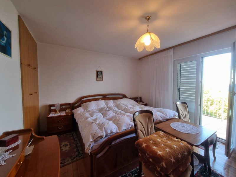 Sypialnia z dużym łóżkiem i wyjściem na balkon w domu w Sveti Juraj w Chorwacji