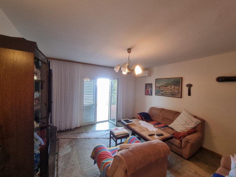 Pokój dzienny z wygodnymi kanapami i szklanymi drzwiami na taras w domu H3052 w Chorwacji.