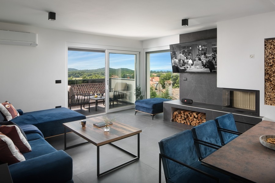 Nowoczesny salon z wysokiej jakości kominkiem i widokiem na morze.