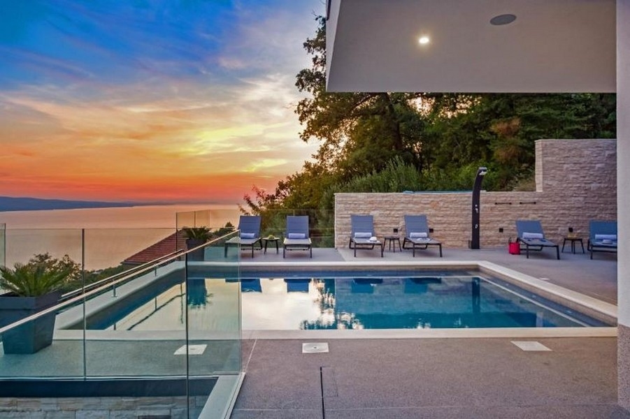Zachód słońca z tarasu z basenem willi H3390, która jest na sprzedaż w Chorwacji.