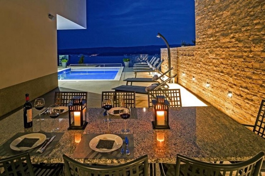 Stół i widok na basen w wieczornej atmosferze.