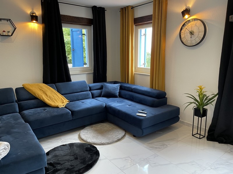 Wysokiej jakości niebieska kanapa i piękne kafelki na podłodze w salonie.