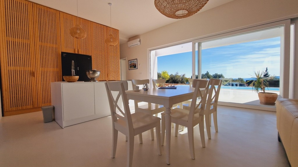 Otwarty salon i jadalnia z widokiem na taras i basen willi na Krk w Chorwacji.