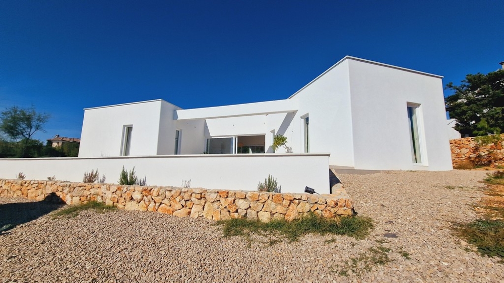 Nowoczesna parterowa willa w Chorwacji z białą fasadą i żwirową ścieżką