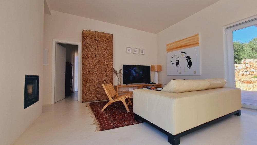 Pokój dzienny z kremową sofą, telewizorem i dekoracyjnymi dziełami sztuki