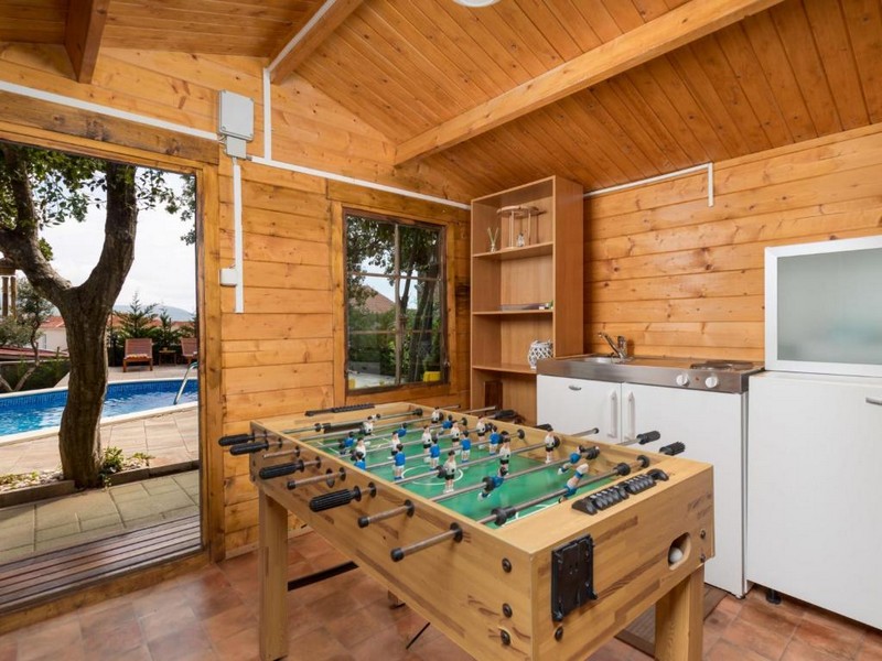 Domek ogrodowy z piłkarzykami i widokiem na basen.