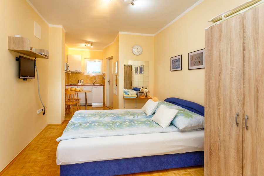 Apartament typu studio z podwójnym łóżkiem, małym stołem jadalnym i aneksem kuchennym