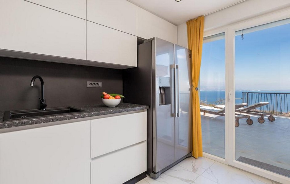 Nowoczesna kuchnia z widokiem na morze i żółtymi zasłonami