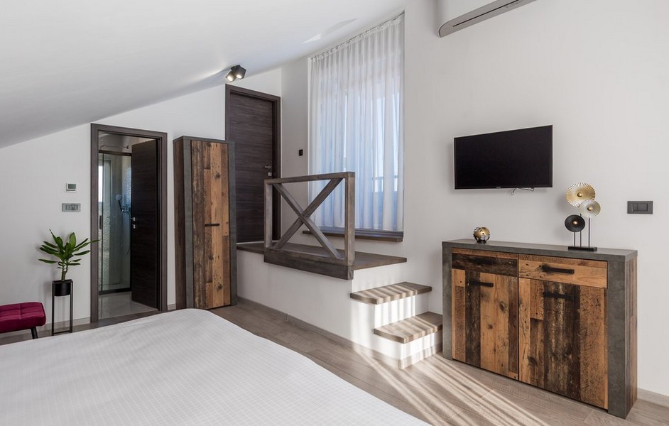 Sypialnia z rustykalnymi drewnianymi meblami i schodami